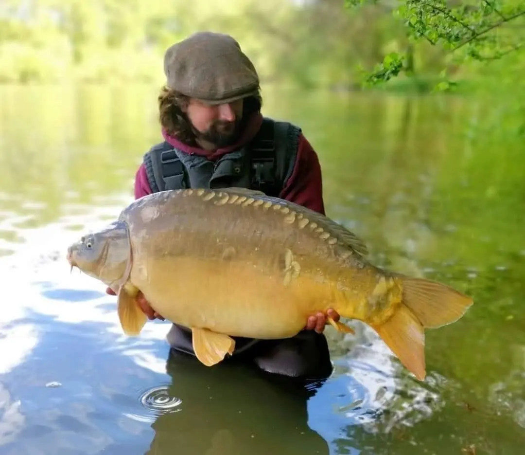 Angler with a carp caught on N.E Baits