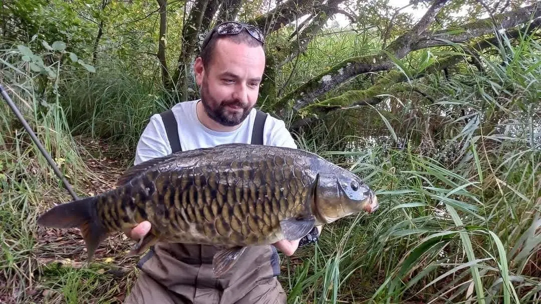 Angler with a carp caught on N.E Baits