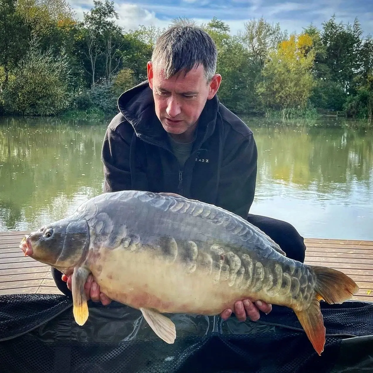 Angler with a carp caught on N.E Baits